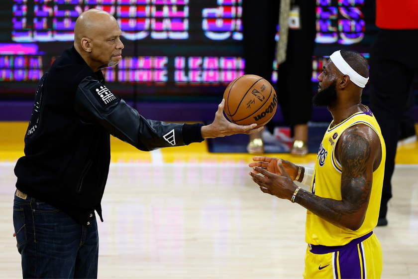 Kareem Abdul-Jabbar ceremoniously hands LeBron James #6 of the Los Angeles Lakers the ball after James passed Abdul-Jabbar to become the NBA's all-time leading scorer, surpassing Abdul-Jabbar's career total of 38,387 points