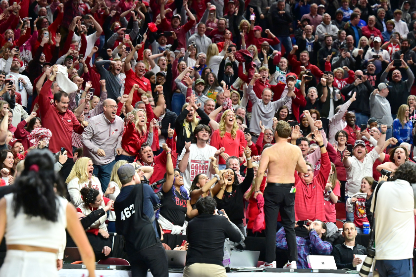 Arkansas Razorbacks coach Eric Musselman removes his shirt and celebrates with the Arkansas fans after upsetting Kansas during the second round of the NCAA Division 1 Men's Basketball Championship West Regional