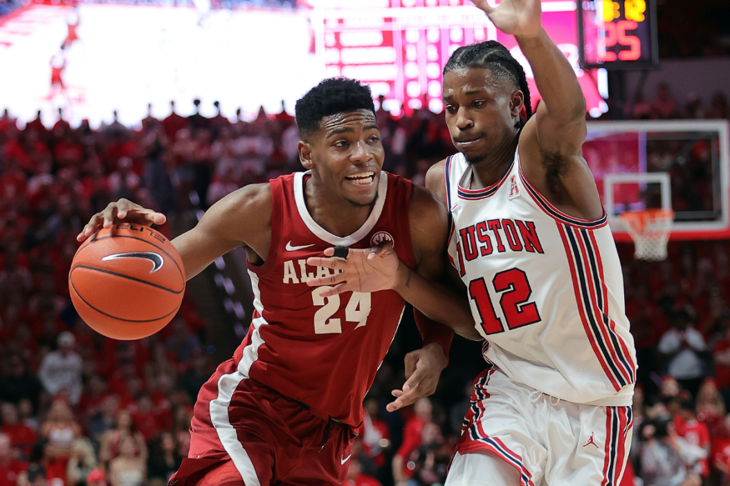 Brandon Miller #24 of the Alabama Crimson Tide drives to the basket on Tramon Mark #12 of the Houston Cougars during the first half at Fertitta Center.