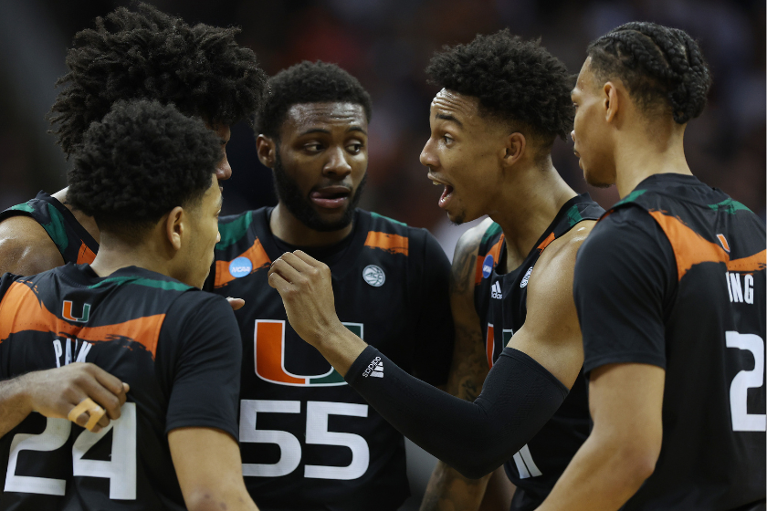 Jordan Miller #11 of the Miami Hurricanes huddles with teammates during the second half against the Texas Longhorns in the Elite Eight round of the NCAA Men's Basketball Tournament at T-Mobile Center 