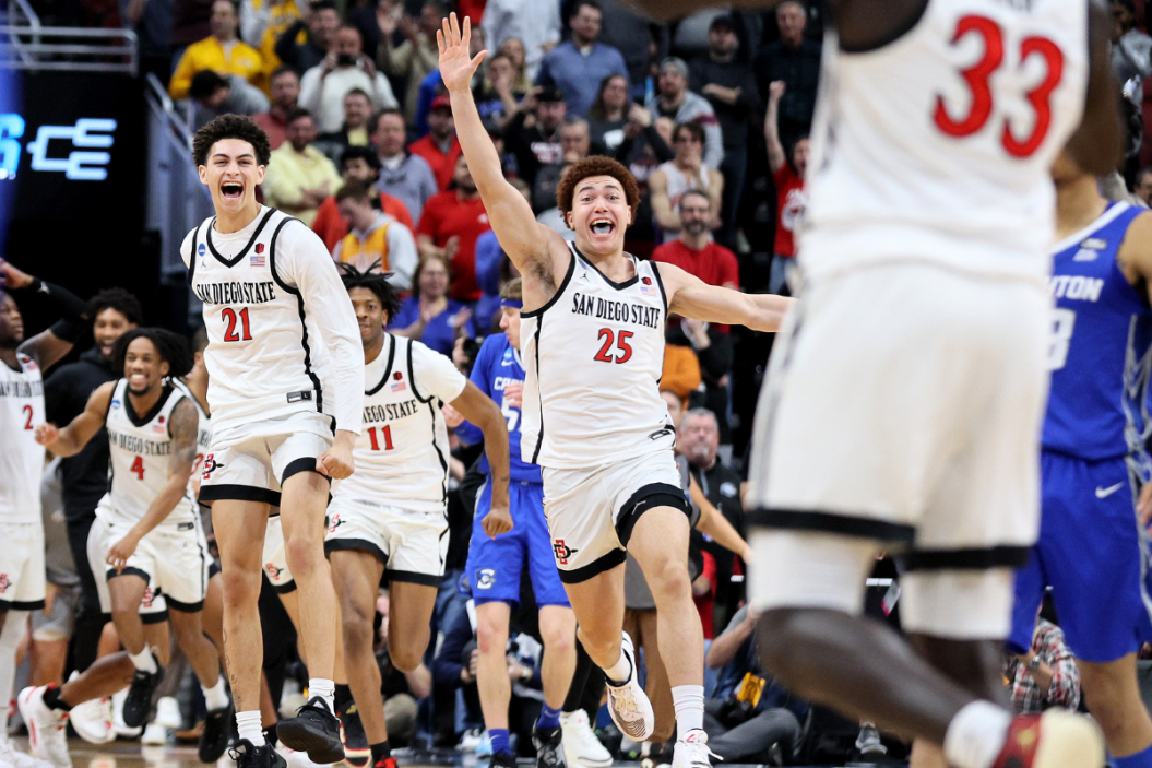 Miles Byrd #21, Demarshay Johnson Jr. #11 and Elijah Saunders #25 of the San Diego State Aztecs run to Aguek Arop #33 to celebrate defeating the Creighton Bluejays in the Elite Eight round of the NCAA Men's Basketball Tournament