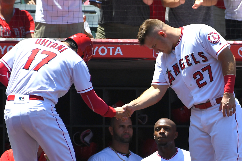 Shohei Ohtani #17 greeted by Mike Trout #27 of the Los Angeles Angels of Anaheim after scoring a run in the second inning of the game against the Texas Rangers at Angel Stadium