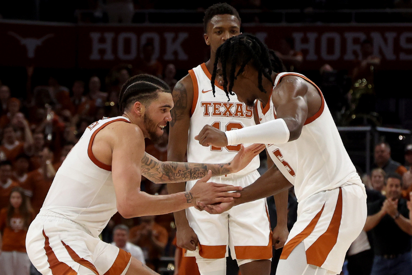 Timmy Allen #0, Marcus Carr #5 and Sir'Jabari Rice #10 of the Texas Longhorns react to scoring against the Oklahoma Sooners during the game at Moody Center