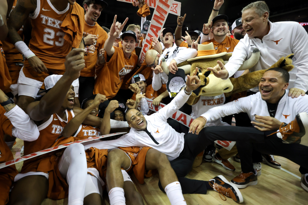 Interim head coach Rodney Terry of the Texas Longhorns celebrates with the team after defeating the Kansas Jayhawks in the Big 12 Tournament Championship game at T-Mobile Center