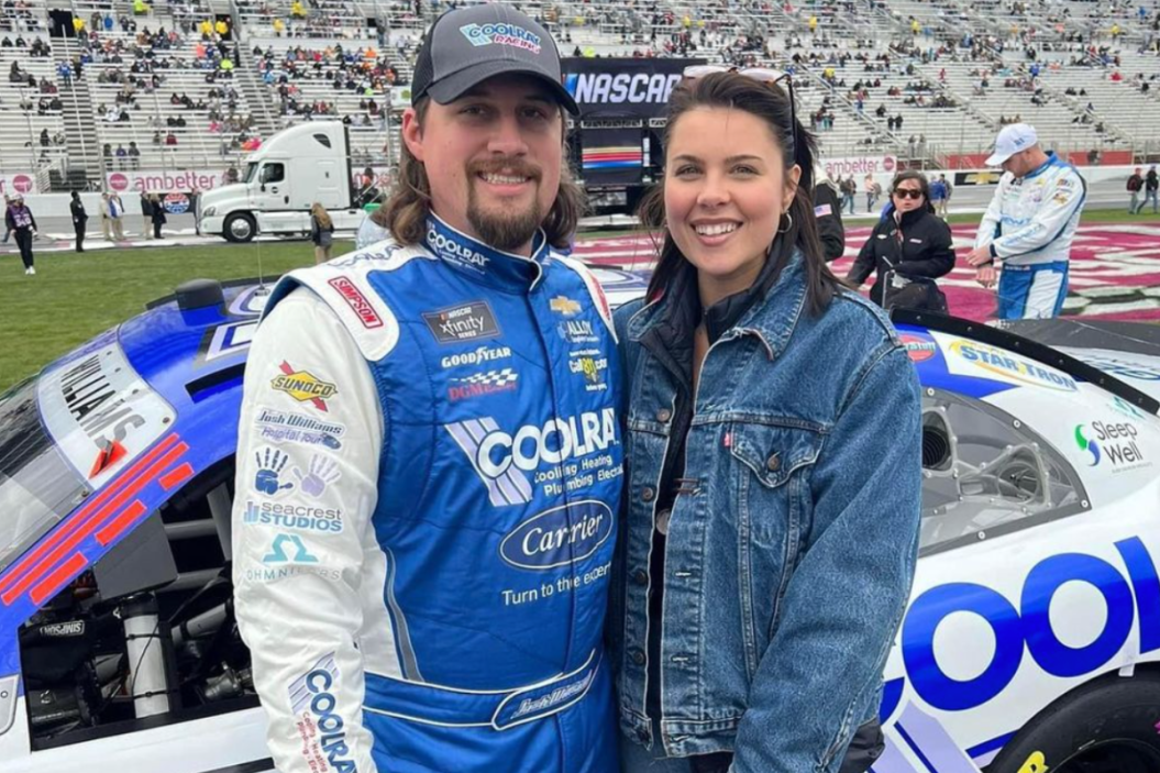 josh williams with wife trazia rae in front of stock car at atlanta motor speedway