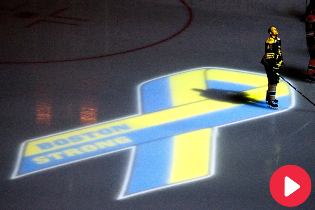 Dennis Seidenberg #44 of the Boston Bruins stands near aa projection of the Boston Marathon Memorial Ribbon seen on the ice during pre game ceremonies in remembrance of the Boston Marathon bombing victims