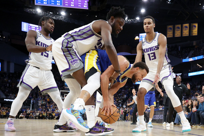 tephen Curry #30 of the Golden State Warriors is surrounded by Davion Mitchell #15, Keegan Murray #13 and fouled by Chimezie Metu #7 of the Sacramento Kings in the final seconds of their game at Chase Center