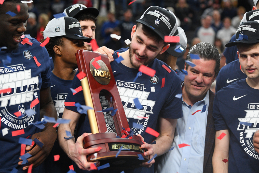 Alex Karaban (11) holds up the trophy after advancing to the Final Four after winning the NCAA Division I Men's Championship Elite Eight round basketball game between the Gonzaga Bulldogs and the UConn Huskies