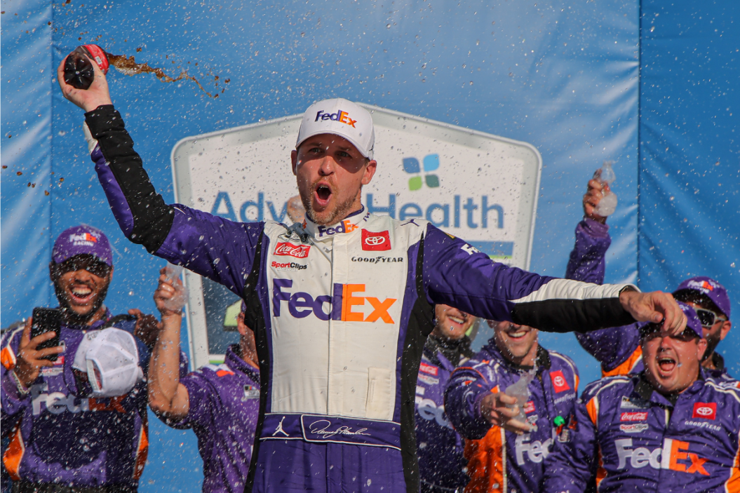 Denny Hamlin celebrates in victory lane after winning the 2023 Advent Health 400 at Kansas Speedway