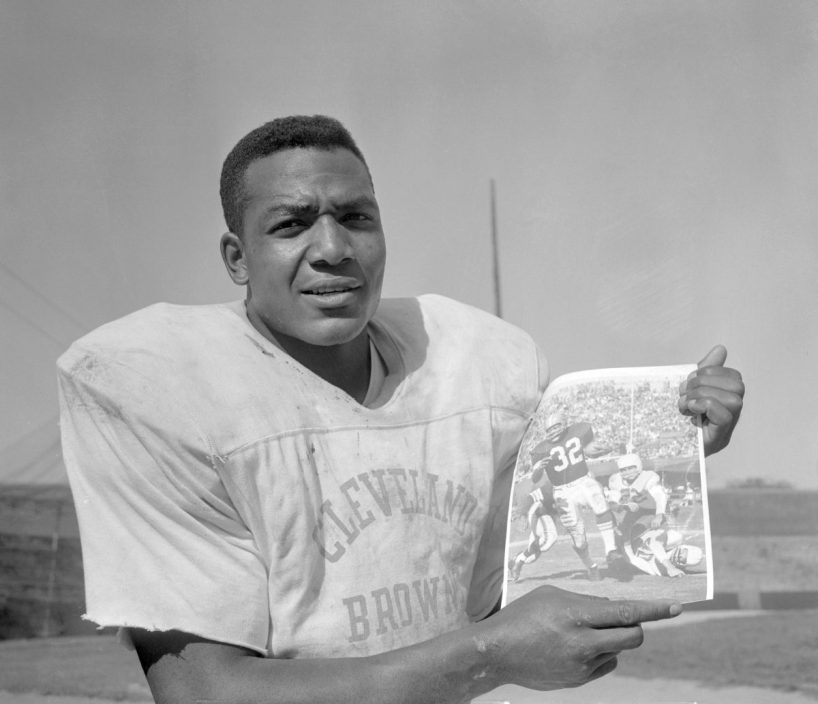 Jim Brown, Cleveland Browns' fullback, holds up a UPI photo of himself in action against the Chicago Cardinals October 12.