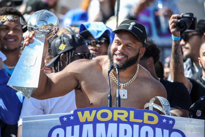 Aaron Donald holds up a trophy at a parade.