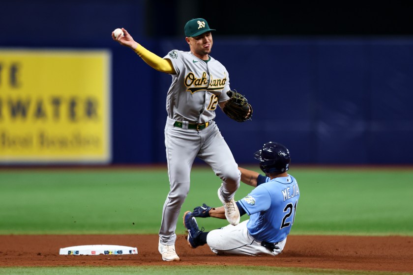 A's shortstop Aledmys Diaz throws the ball to first base.