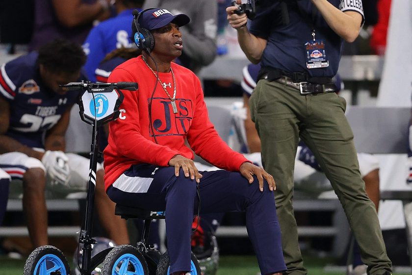 Deion Sanders on the sideline with a bandage around his left foot.