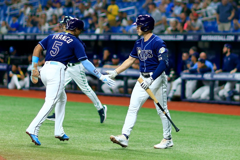 Rays players high five during a game.
