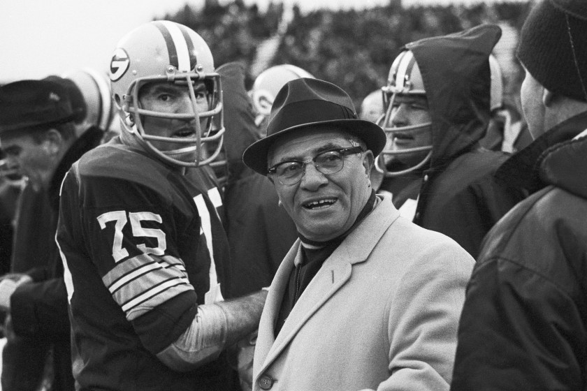 Vince Lombardi smiles on the sideline.