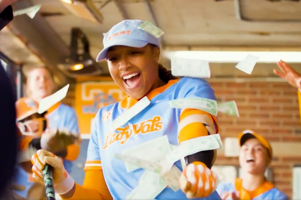 A Tennessee softball player celebrates in the dugout with a Mommy hat on her head.
