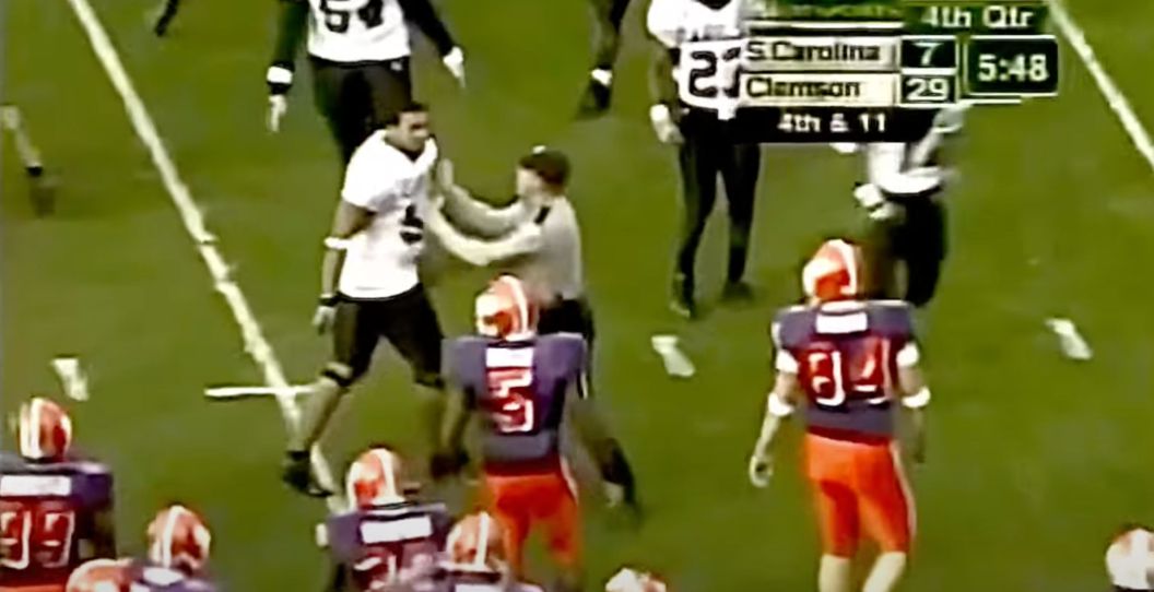 A South Carolina player is held by police during a 2004 fight against Clemson.