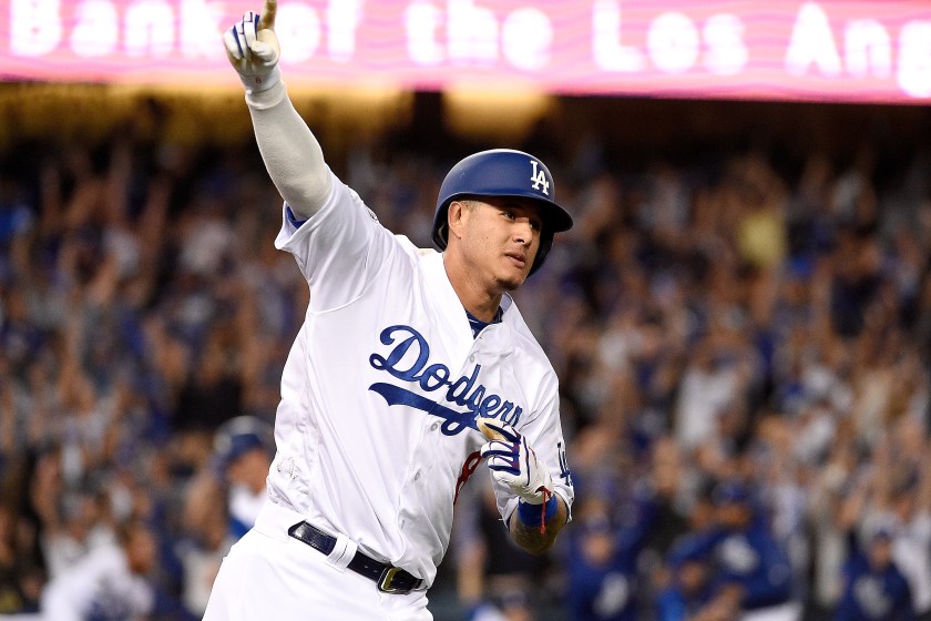 Manny Machado holds up his fingers while rounding the bases for the Dodgers.