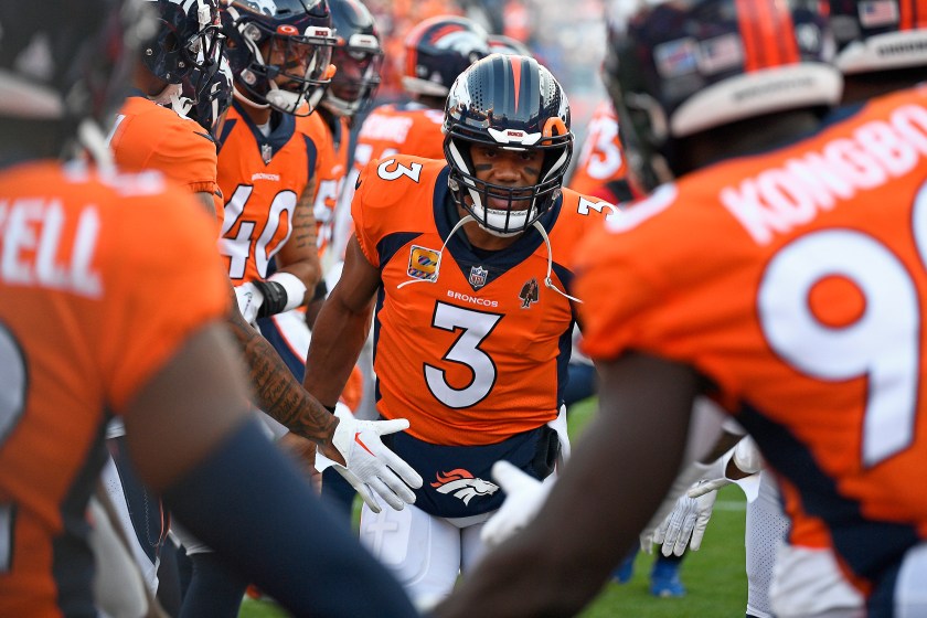 Denver Broncos QB Russell Wilson goes through a high-five line before a game.