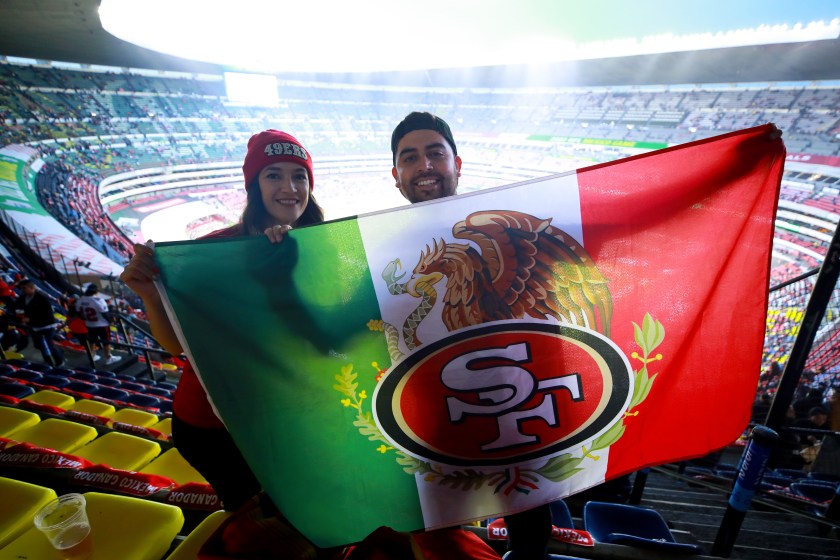 Fans pose with a 49ers Mexico flag.