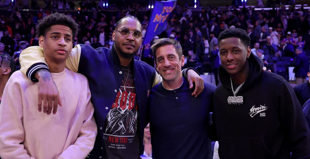 Carmelo Anthony with his son, Kiyan, take a picture with Aaron Rodgers and Sauce Gardner.