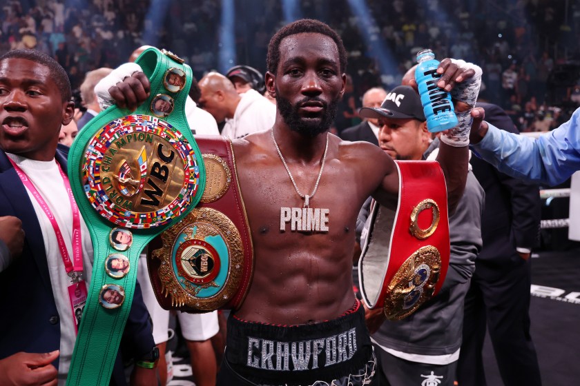 Terence Crawford holds up his championship belts.