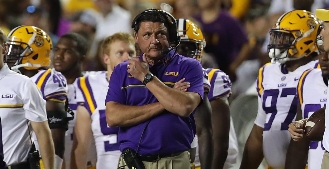 LSU head coach Ed Orgeron stands on the sideline with his team.
