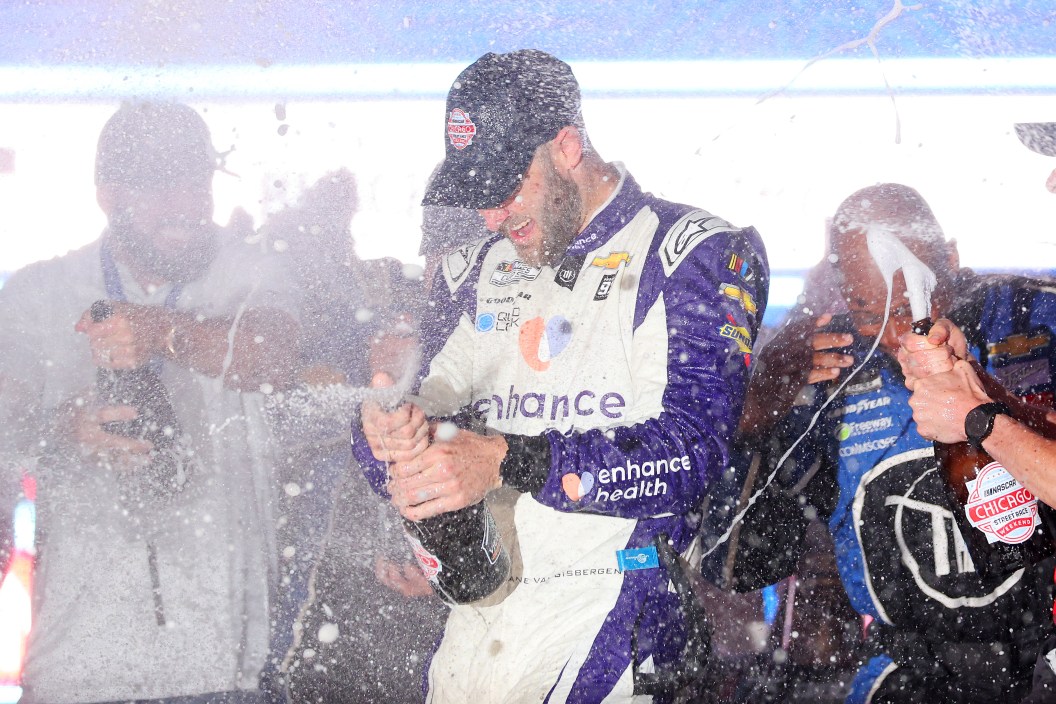 CHICAGO, ILLINOIS - JULY 02: Shane Van Gisbergen, driver of the #91 Enhance Health Chevrolet, and crew celebrate by spraying champagne in victory lane after winning the NASCAR Cup Series Grant Park 220 at the Chicago Street Course on July 02, 2023 in Chicago, Illinois.