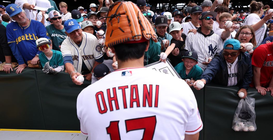 Shohei Ohtani signs autographs before the All-Star workout in Seattle.