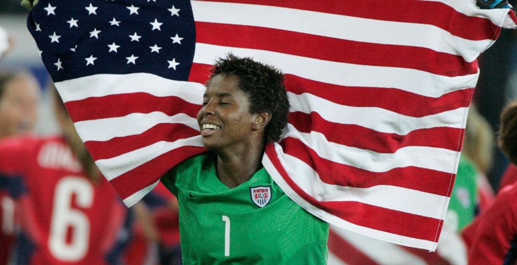 Briana Scurry holds up an American flag.