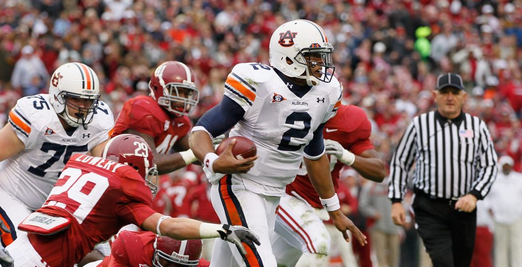 TUSCALOOSA, AL - NOVEMBER 26: Quarterback Cam Newton #2 of the Auburn Tigers rushes upfield away from Will Lowery #29 and Marcell Dareus #57 of the Alabama Crimson Tide at Bryant-Denny Stadium on November 26, 2010 in Tuscaloosa, Alabama.