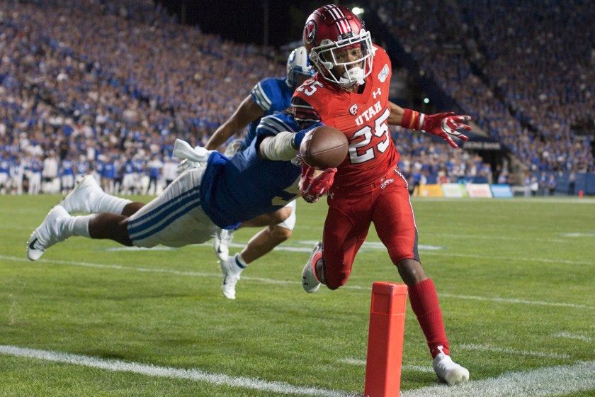 PROVO, UT - AUGUST 29: Jaylen Dixon #25 of the Utah Utes gets the ball into the end zone for a touchdown  as Dayan Ghanwoloku #5 of the BYU Cougars tries to strip the ball during their game at LaVell Edwards Stadium on August 29, in Provo, Utah. 