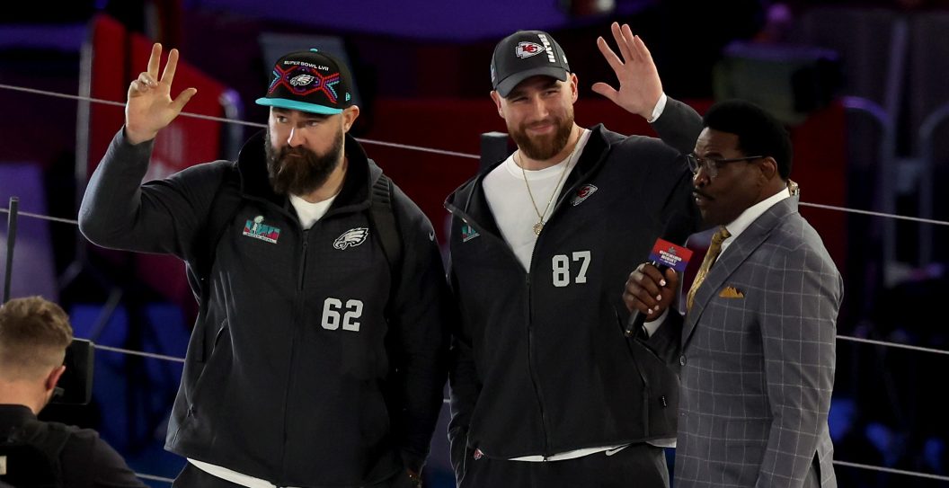 PHOENIX, ARIZONA - FEBRUARY 06: (L-R) Brothers Jason Kelce #62 of the Philadelphia Eagles and Travis Kelce #87 of the Kansas City Chiefs wave onstage during Super Bowl LVII Opening Night presented by Fast Twitch at Footprint Center on February 06, 2023 in Phoenix, Arizona.
