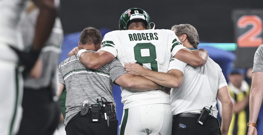 EAST RUTHERFORD, NEW JERSEY - SEPTEMBER 11: Aaron Rodgers #8 of the New York Jets is helped off the field after suffering an apparent injury after being sacked by Leonard Floyd #56 of the Buffalo Bills during a game at MetLife Stadium on September 11, 2023 in East Rutherford, New Jersey.