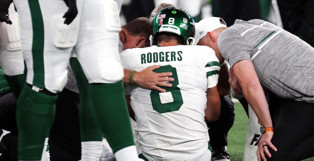 EAST RUTHERFORD, NEW JERSEY - SEPTEMBER 11: Quarterback Aaron Rodgers #8 of the New York Jets is attended to after being sacked by Leonard Floyd #56 of the Buffalo Bills and suffering an apparent Achilles injury in the game at MetLife Stadium on September 11, 2023 in East Rutherford, New Jersey.