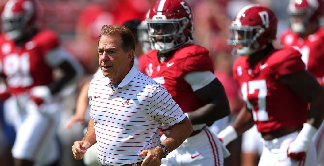 Nick Saban runs in front of his players.