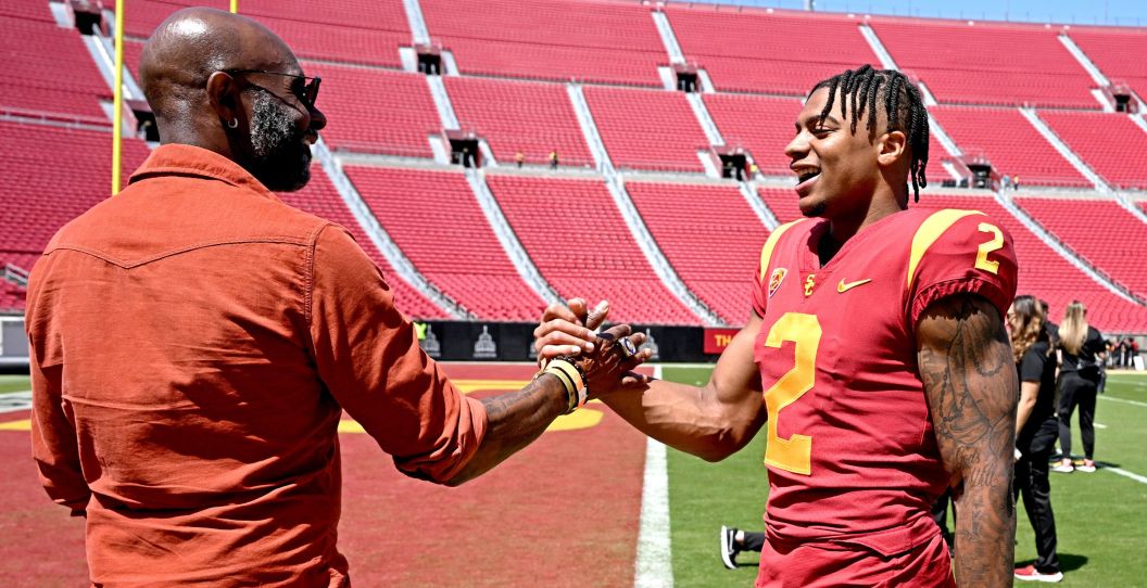 Brenden Rice and Jerry Rice embrace at USC's stadium.