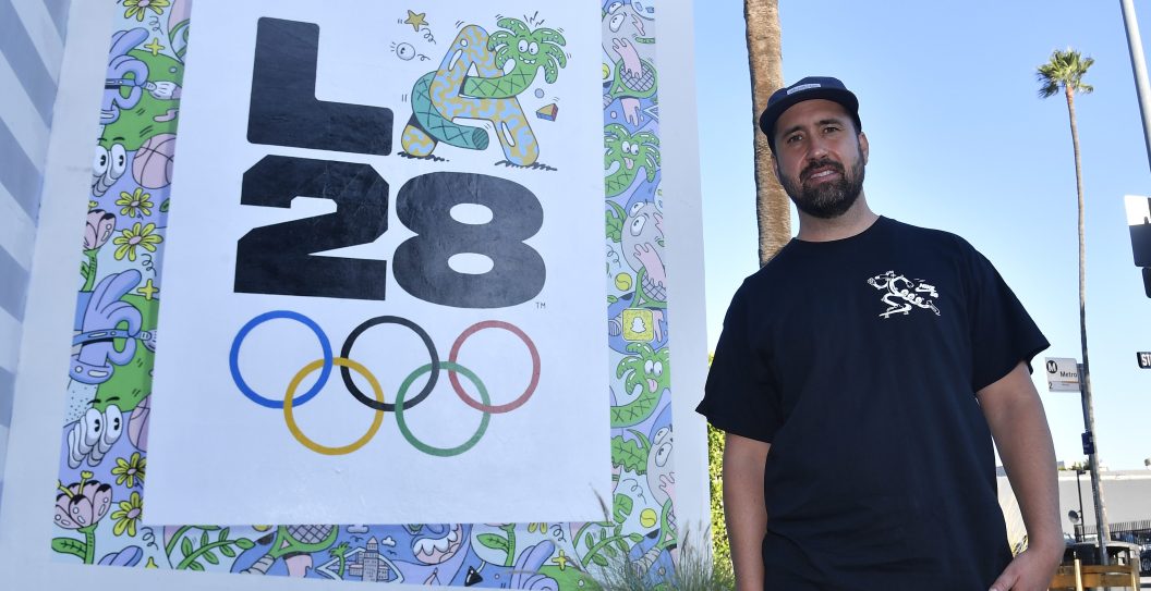 LOS ANGELES, CALIFORNIA - SEPTEMBER 01: Artist Steven Harrington poses in from of his LA28 Olympic mural on the corner of Stanley street and Sunset Boulevard on September 01, 2020 in Los Angeles, California. The mural is one of three LA28 logo murals revealed throughout Los Angeles to celebrate the upcoming Games of the XXXIV Olympiad. The 2028 Summer Olympics are scheduled to take place from July 21, 2028 to August 6, 2028.
