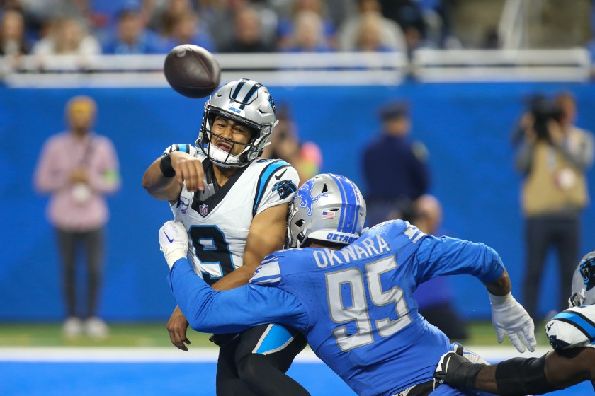 DETROIT, MI - OCTOBER 08:  Carolina Panthers quarterback Bryce Young (9) throws the ball as he takes a hit from Detroit Lions defensive end Romeo Okwara (95) during the third quarter of an NFL football game between the Carolina Panthers and the Detroit Lions on October 8, 2023 at Ford Field in Detroit, 