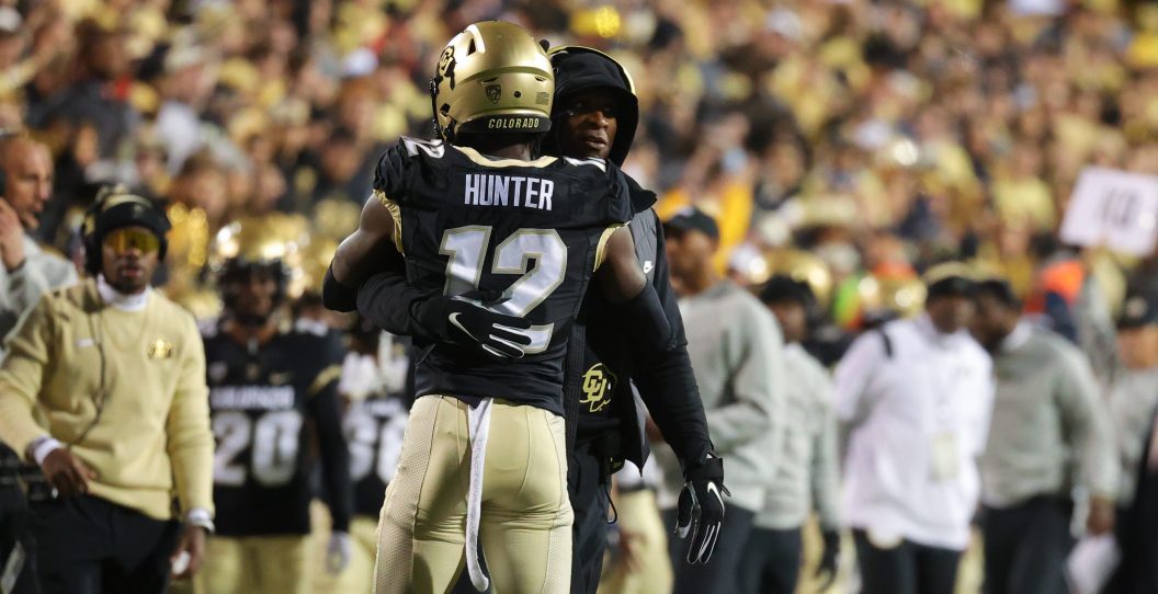 BOULDER, COLORADO - OCTOBER 13: Head coach Deion Sanders embraces Travis Hunter #12 of the Colorado Buffaloes after his touchdown in the first quarter against the Stanford Cardinal at Folsom Field on October 13, 2023 in Boulder, Colorado.