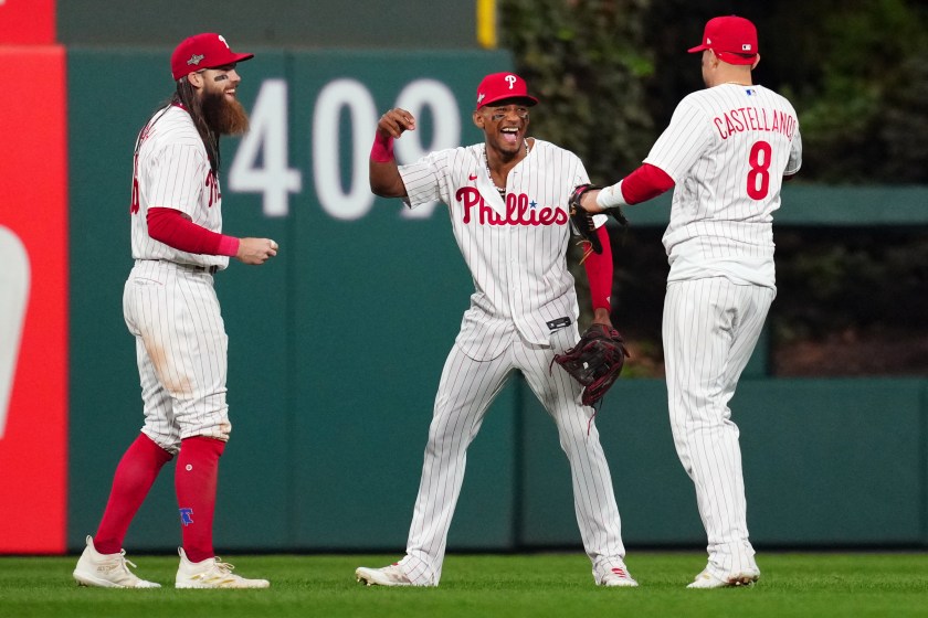 Phillies outfielders celebrate with each other.