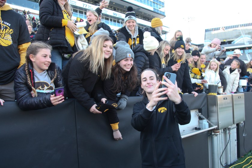 Caitlin Clark takes a selfie with fans.