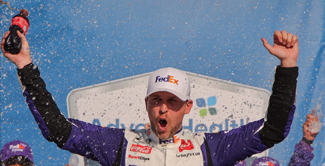 KANSAS CITY, KANSAS - MAY 07: Denny Hamlin, driver of the #11 FedEx Express Toyota, celebrates in victory lane after winning the NASCAR Cup Series Advent Health 400 at Kansas Speedway on May 07, 2023 in Kansas City, Kansas.