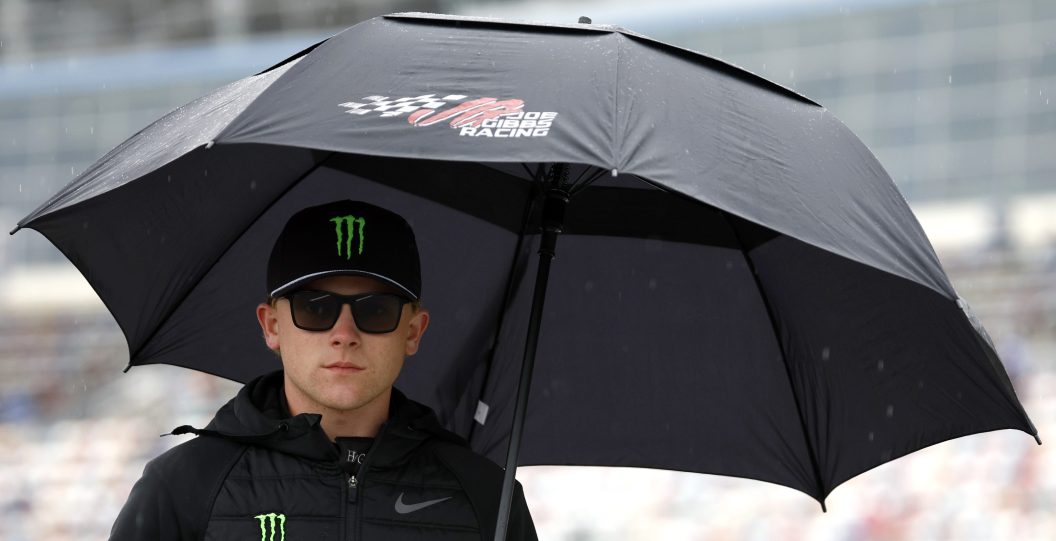 CONCORD, NORTH CAROLINA - MAY 27: Ty Gibbs, driver of the #19 He Gets Us Toyota, waits on the grid under an umbrella prior to the NASCAR Xfinity Series Alsco Uniforms 300 at Charlotte Motor Speedway on May 27, 2023 in Concord, North Carolina.