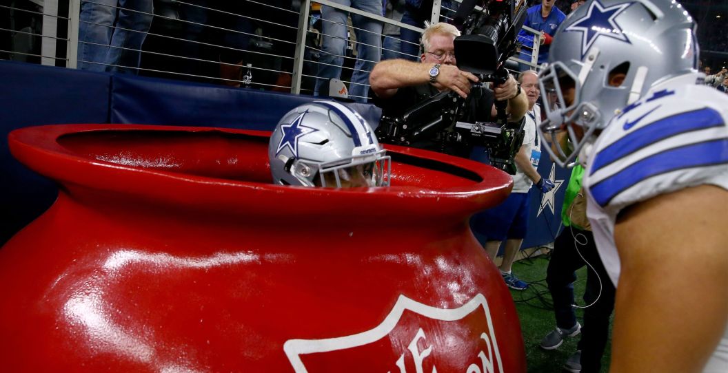 A cowboys player hides in the Red Kettle during a game.