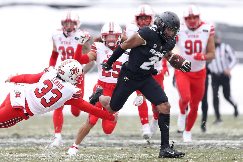 A Colorado player runs from a Utah player.