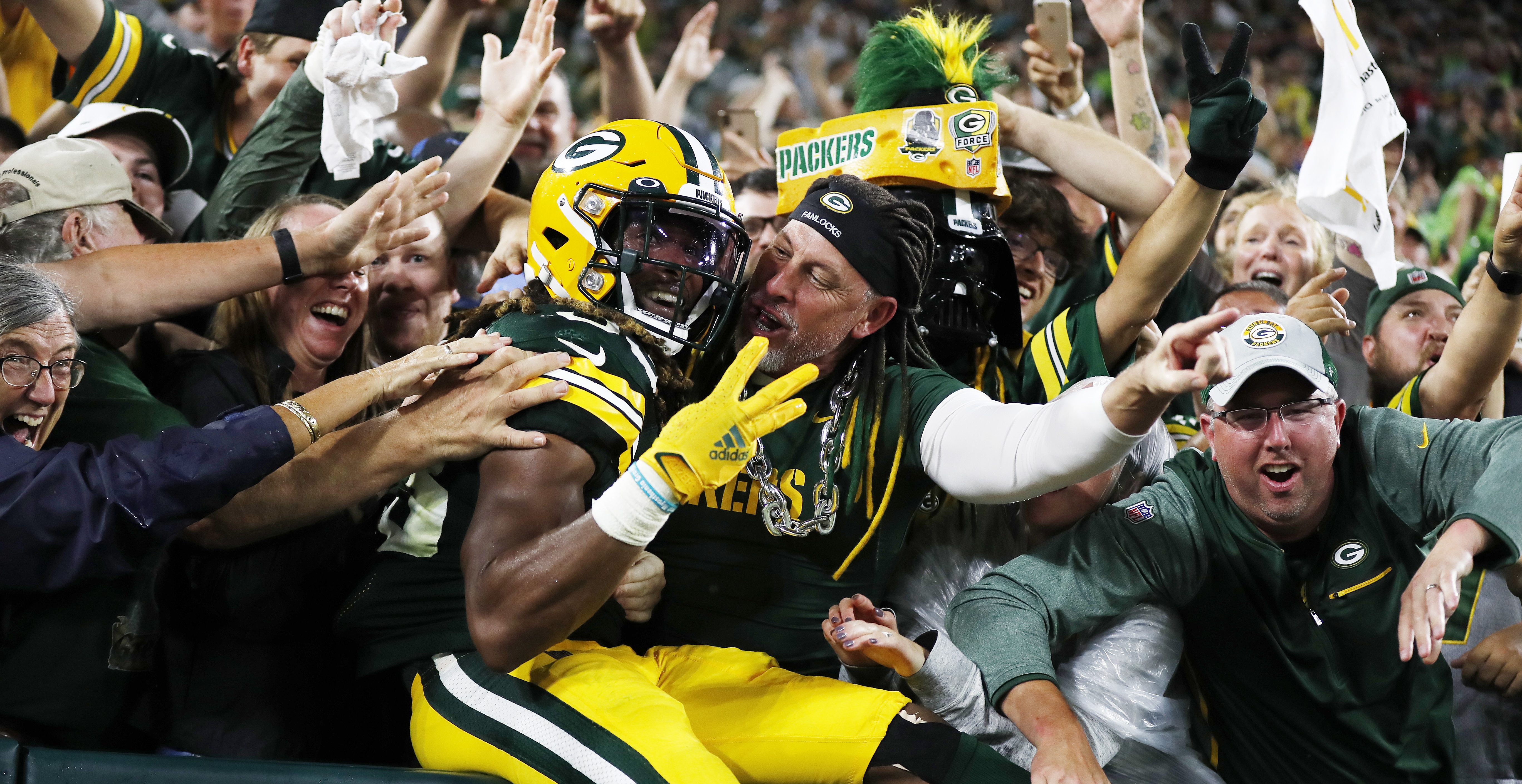 GREEN BAY, WISCONSIN - SEPTEMBER 20: Aaron Jones #33 of the Green Bay Packers does the Lambeau Leap to celebrate his third touchdown of the night against the Detroit Lions during the second half at Lambeau Field on September 20, 2021 in Green Bay, Wisconsin.