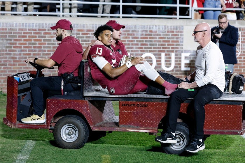 TALLAHASSEE, FL - NOVEMBER 18: Quarterback Jordan Travis #13 of the Florida State Seminoles is carted off the field after an ankle jury during the game against the North Alabama Lions on Bobby Bowden Field at Doak Campbell Stadium on November 18, 2023 in Tallahassee, Florida. The 4th ranked Seminoles defeated the Lions 58 to 13. 
