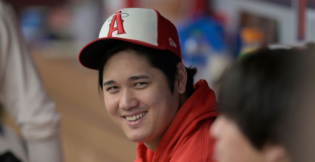 Shohei Ohtani smiles from the dugout.
