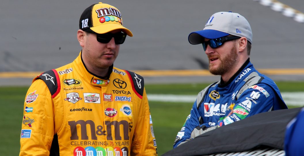 DAYTONA BEACH, FL - FEBRUARY 14: Kyle Busch, driver of the #18 M&M's 75 Toyota, talks with Dale Earnhardt Jr., driver of the #88 Nationwide Chevrolet, on the grid during qualifying for the NASCAR Sprint Cup Series Daytona 500 at Daytona International Speedway on February 14, 2016 in Daytona Beach, Florida.